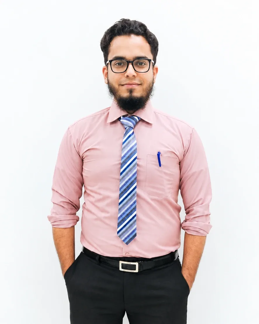 Maaz Ahmed, smiling, wearing glasses, a pink shirt and a blue striped tie