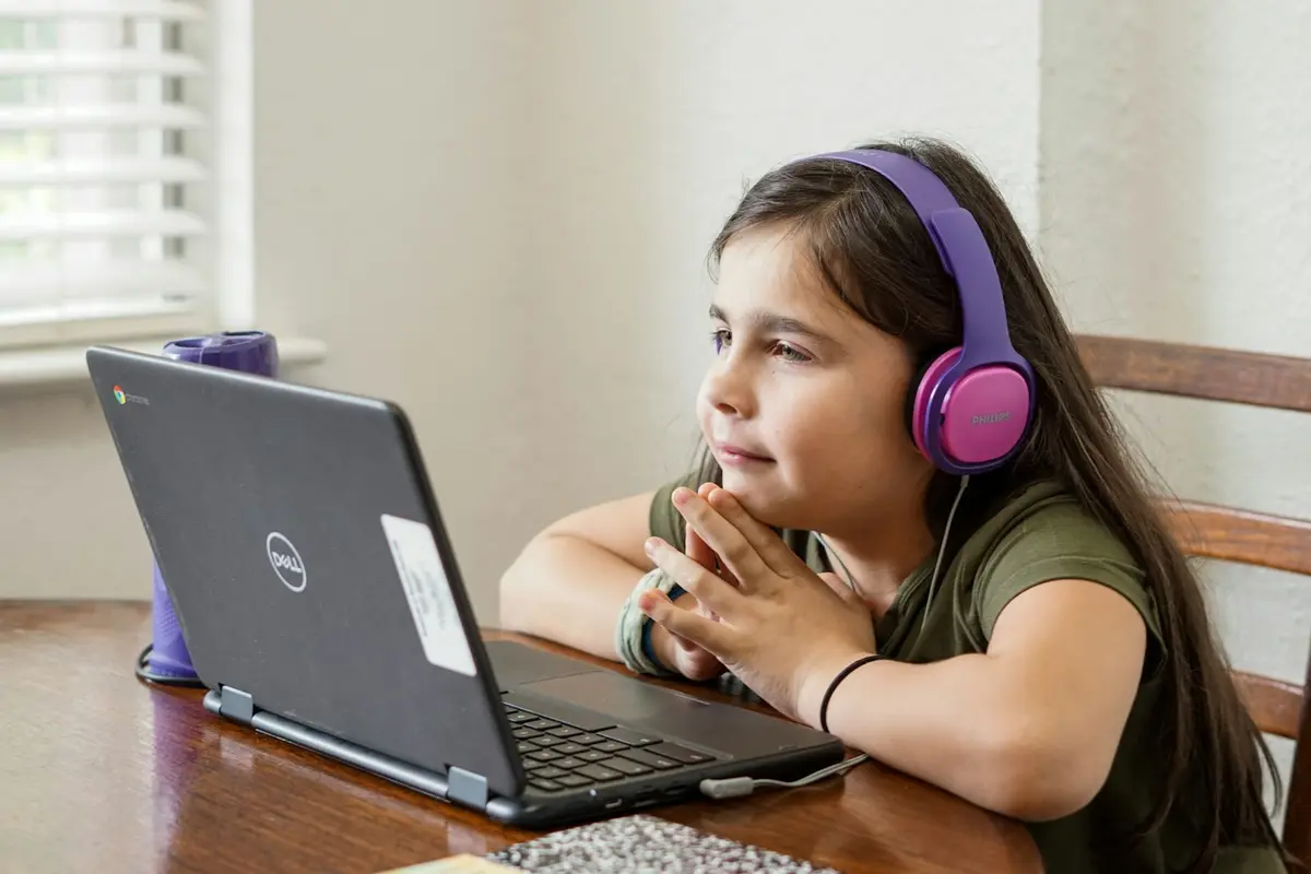 Young girl with headphones learning on a laptop